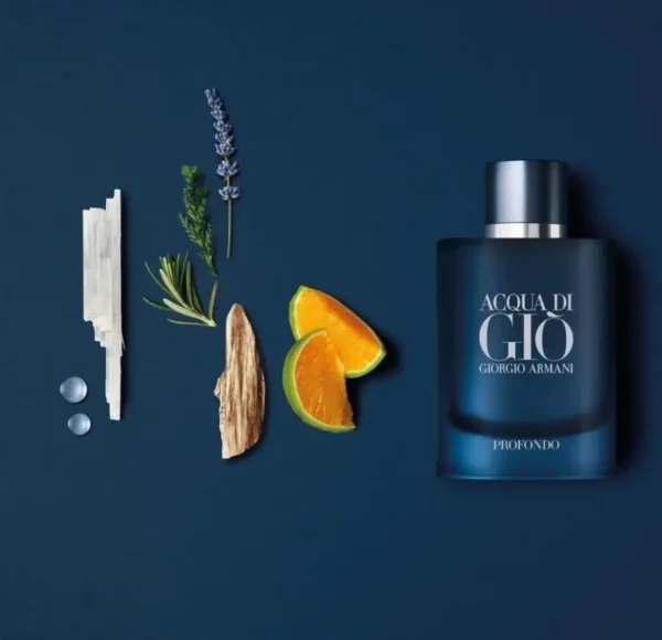 Flakon perfum Giorgio Armani Acqua di Gio Profondo w odcieniach granatu, leżący na ciemnoniebieskim tle obok patyczków, lawendy i plasterków cytrusów.